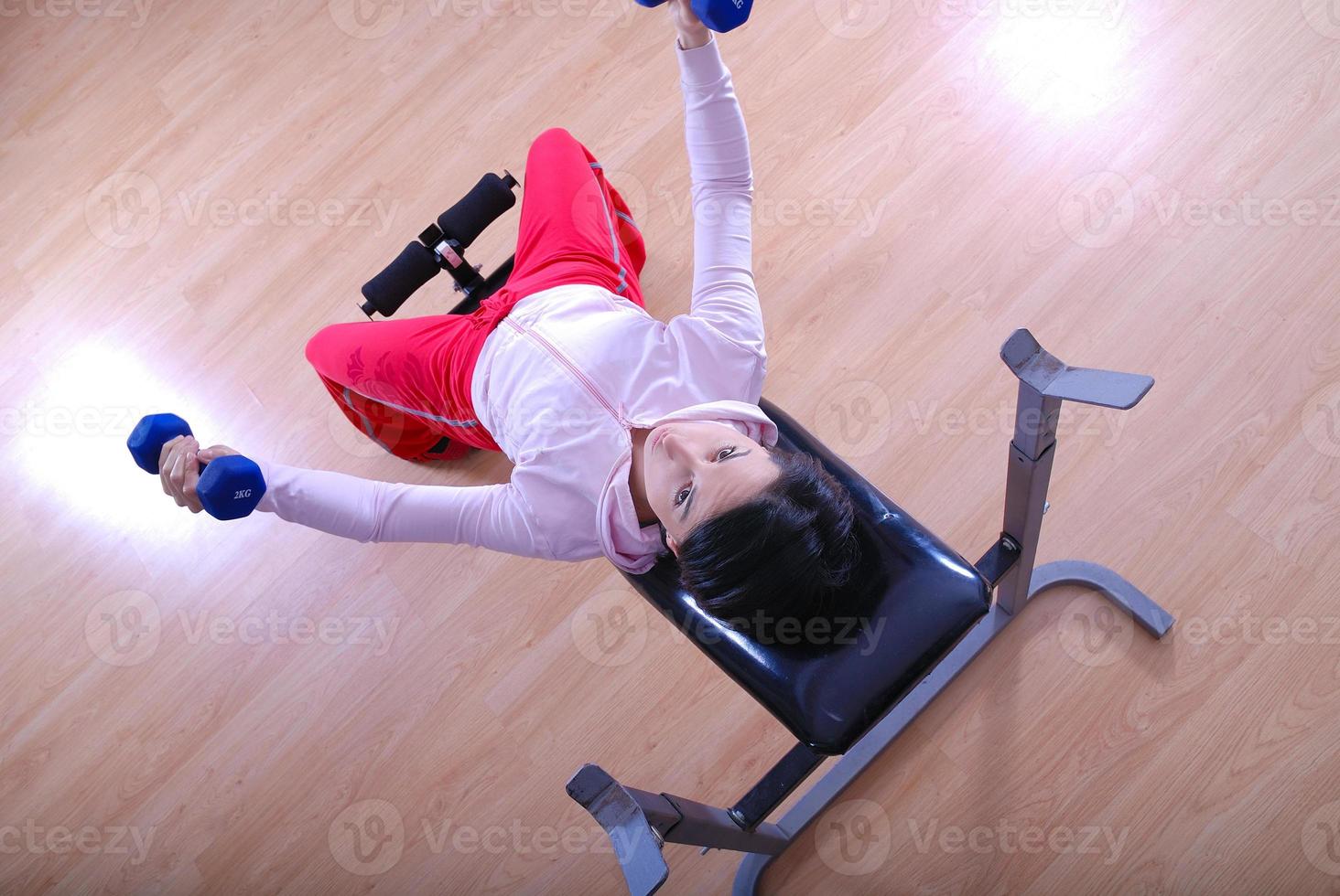 .a young woman weightlifting at gym photo