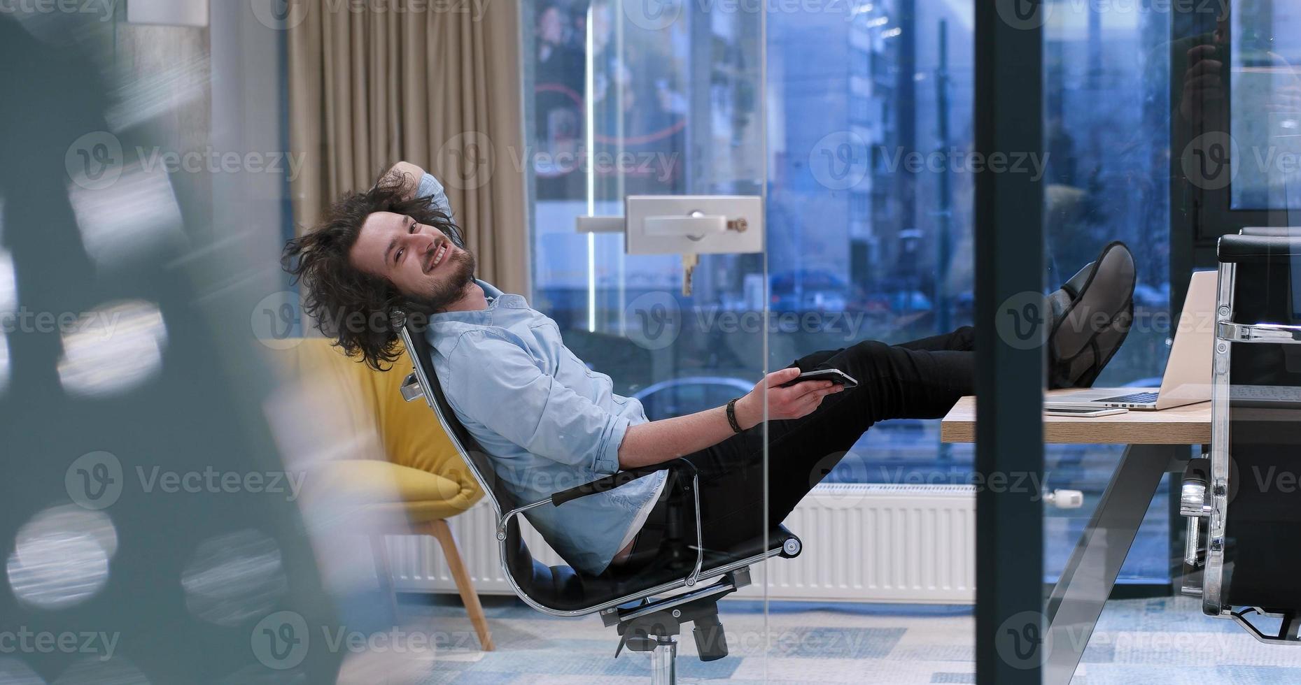 businessman sitting with legs on desk photo