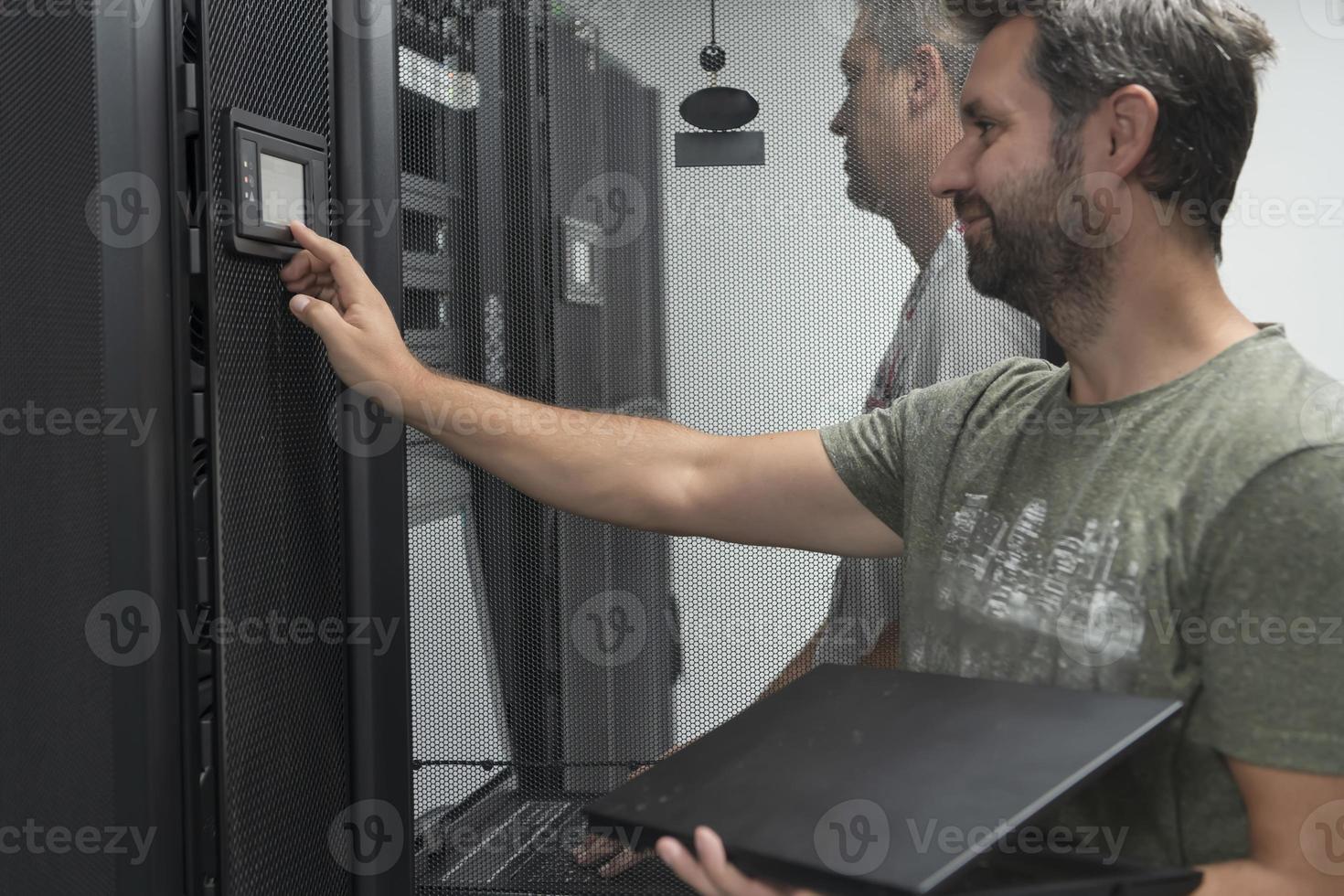 Technicians team updating hardware inspecting system performance in super computer server room or cryptocurrency mining farm. photo