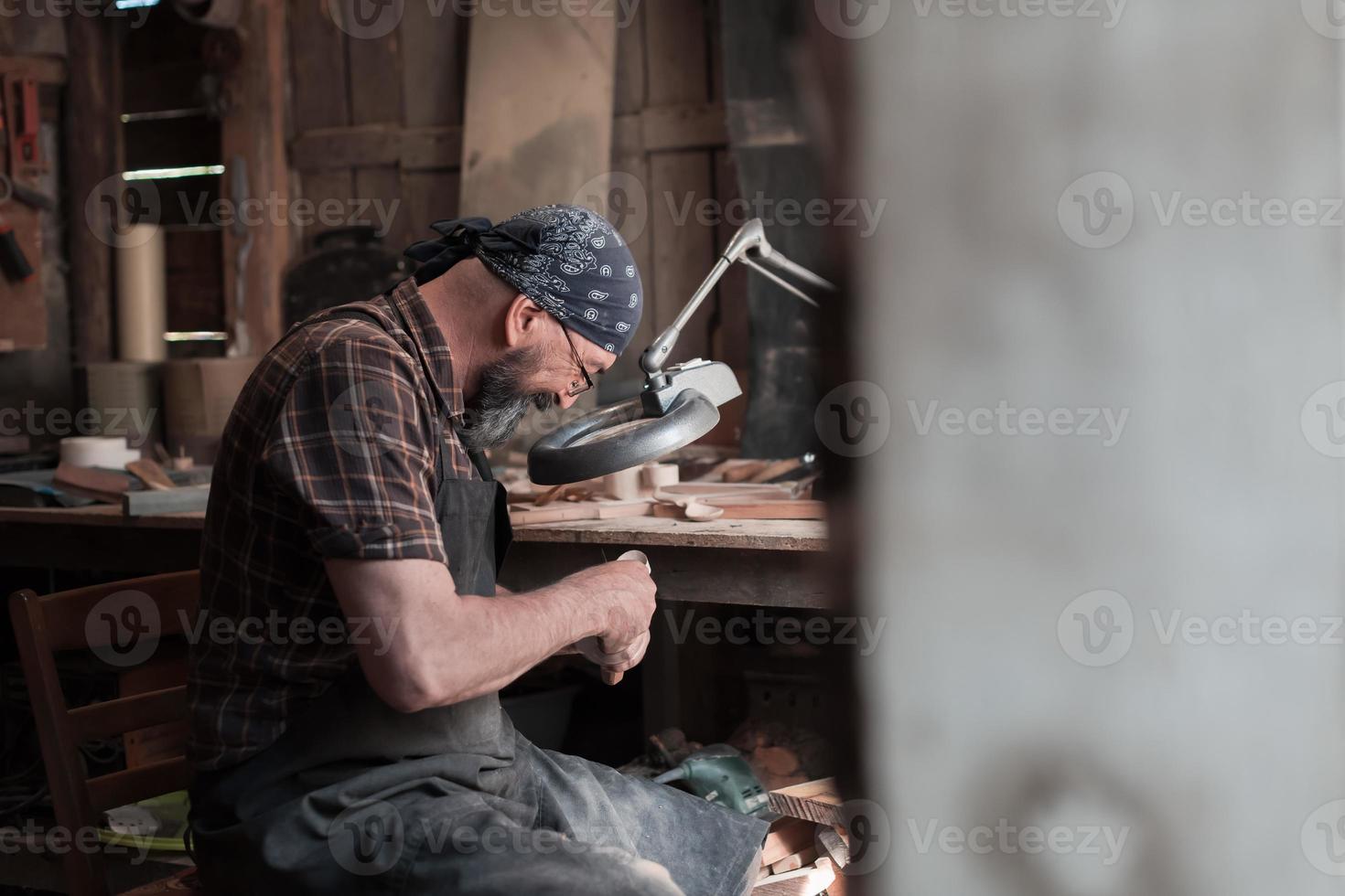 Spoon master in his workshop with wooden products and tools photo