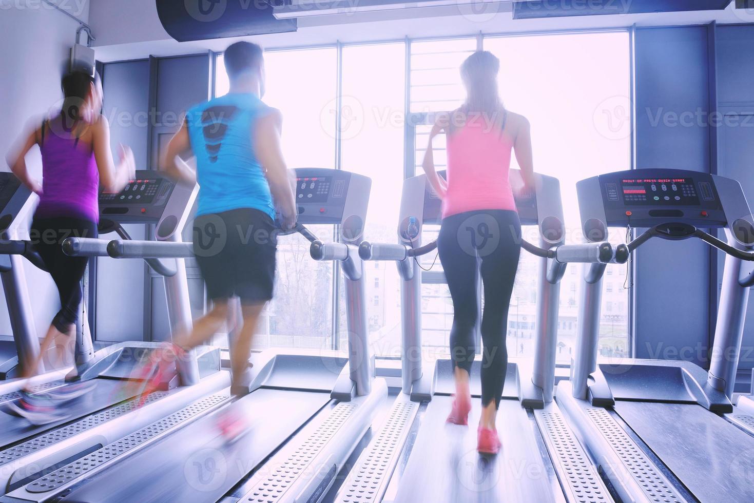 Group of people running on treadmills photo