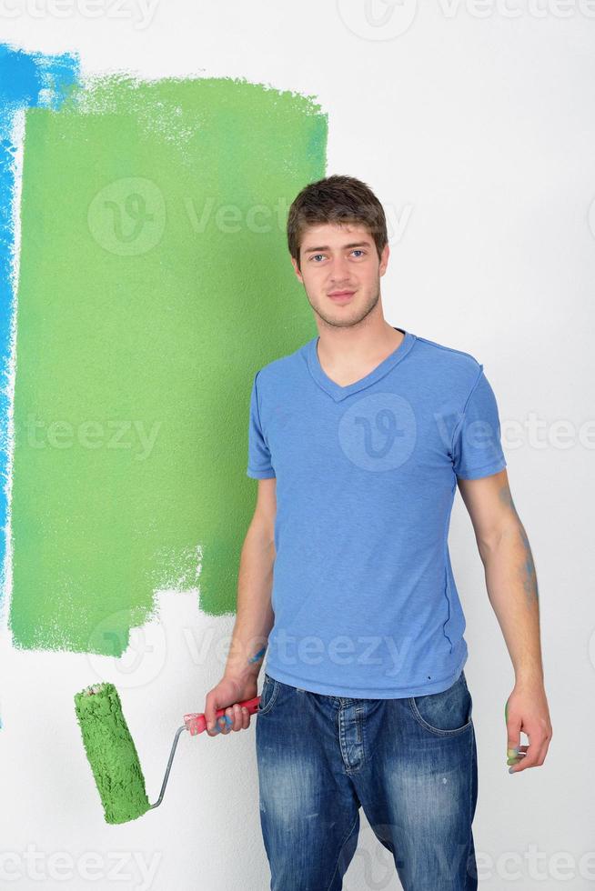 handsome young man paint white wall in color photo