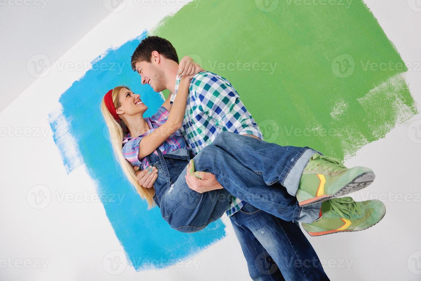 happy couple paint wall at new home photo