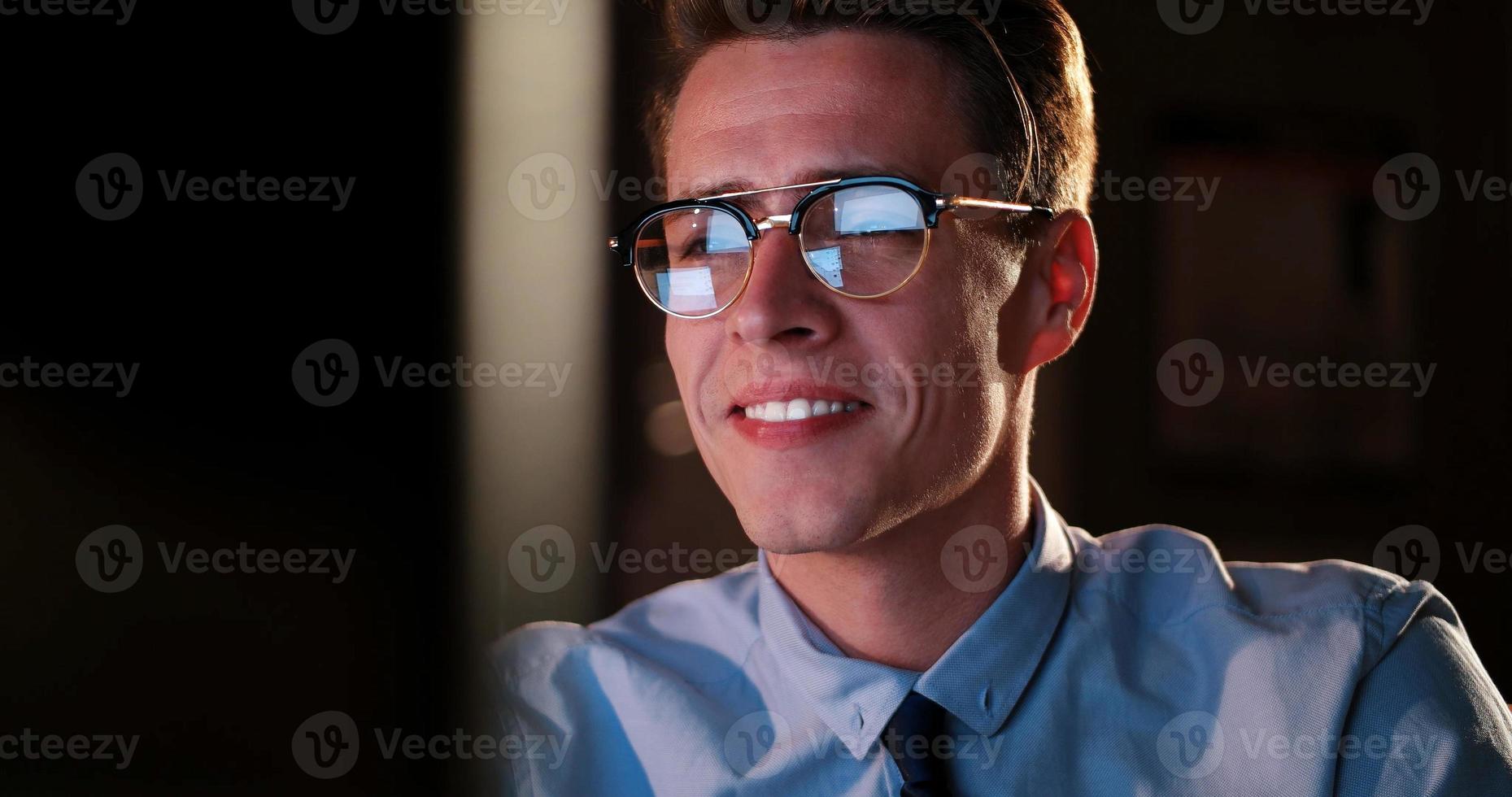 man working on computer in dark office photo