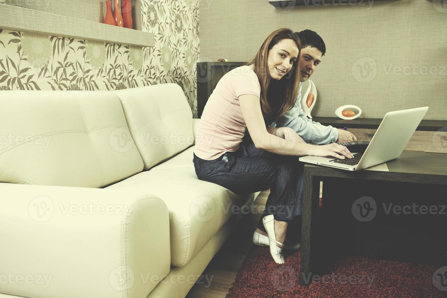 young couple working on laptop at home photo