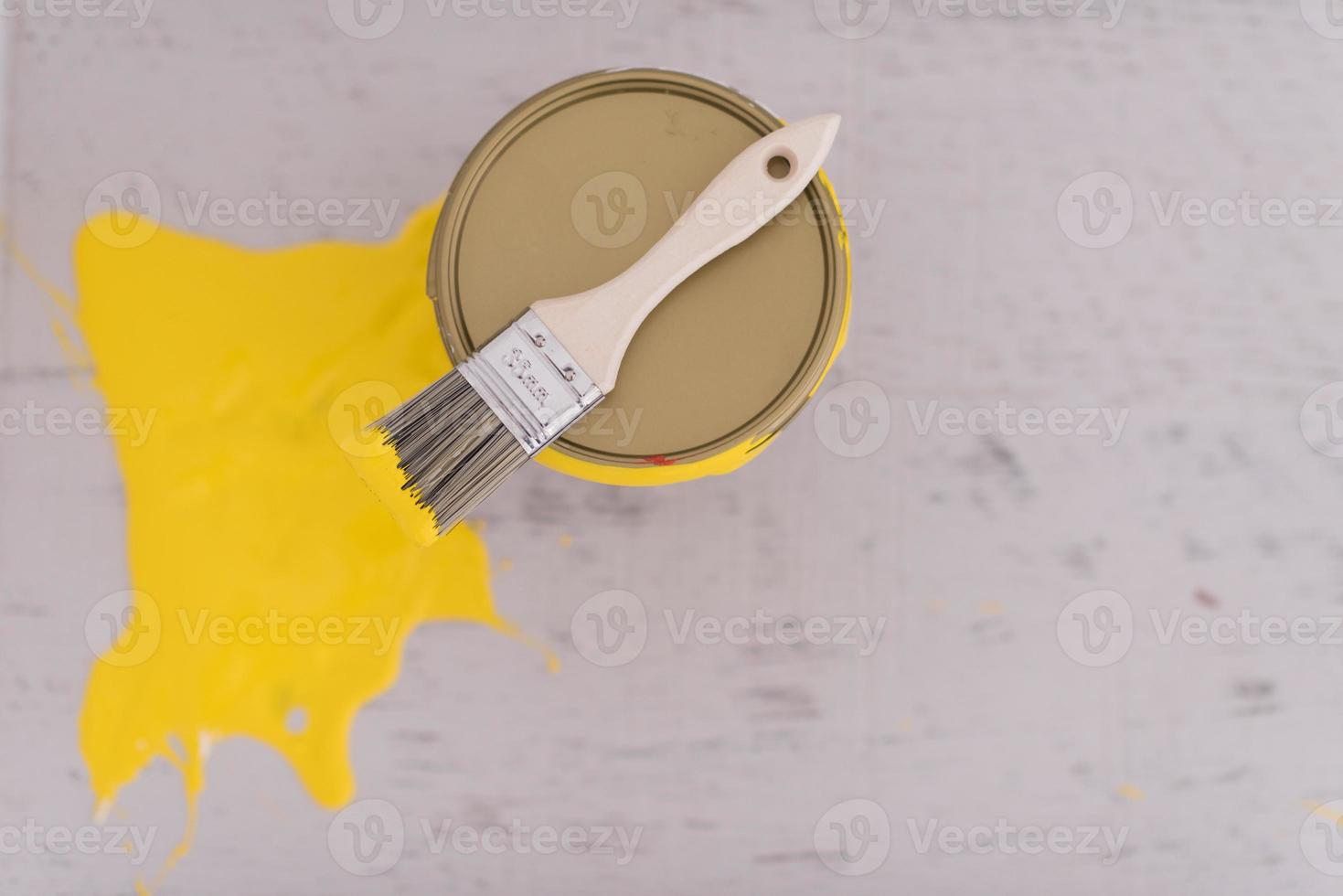 Yellow paint tin can with brush on top photo