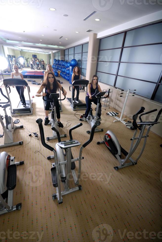 Women working out on spinning bikes at the gym photo