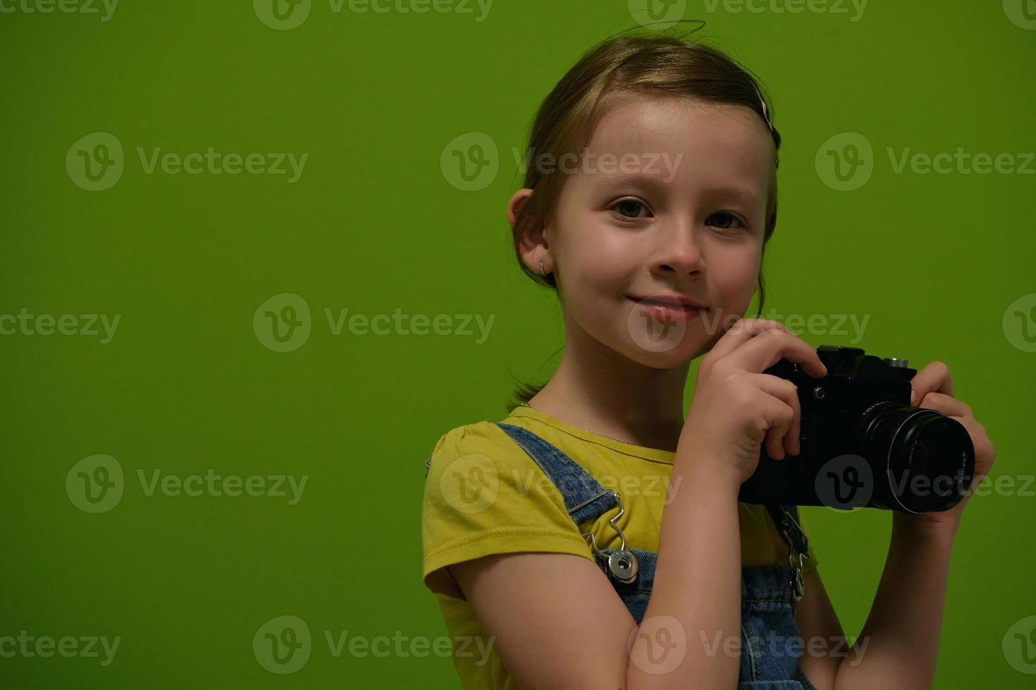 Cute little girl taking picture using  film photo camera