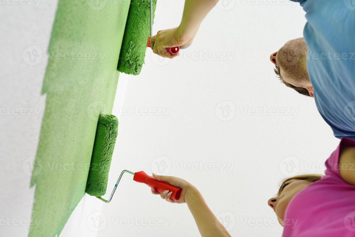 happy couple paint wall at new home photo