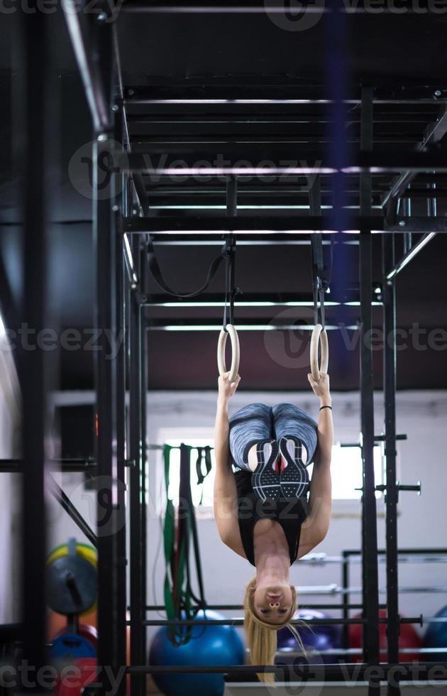 mujer trabajando en anillos de gimnasia foto