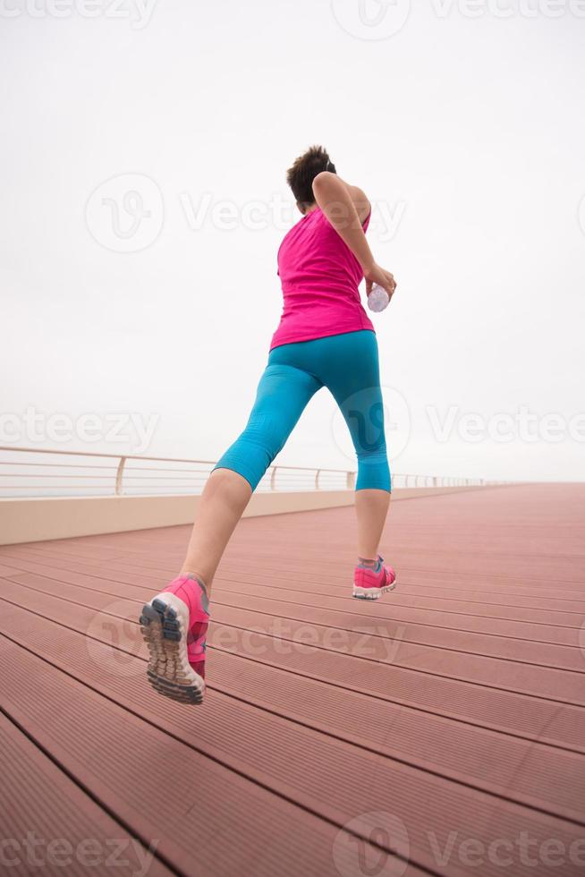 woman busy running on the promenade photo