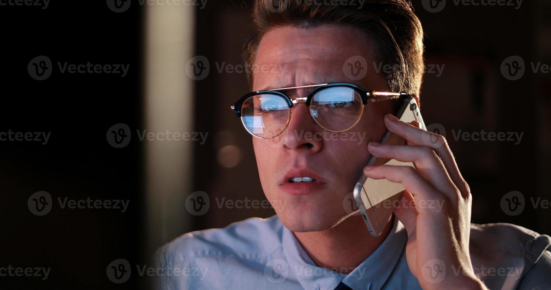 man using mobile phone in dark office photo