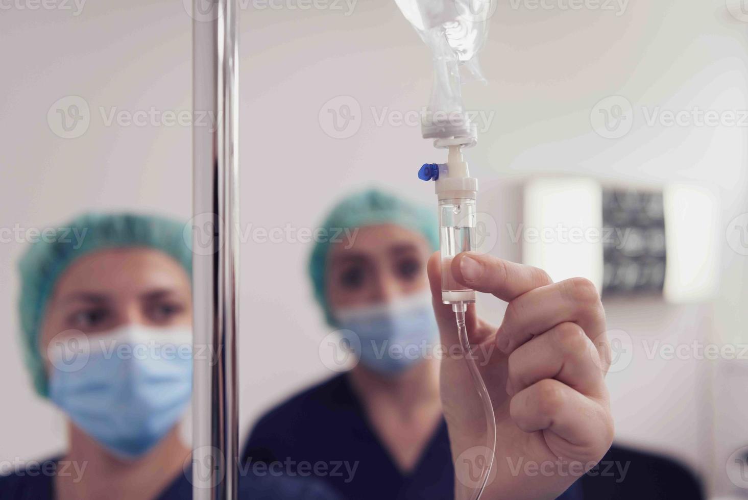 médico general con infusión intravenosa por goteo. médico que maneja el goteo de líquido intravenoso con espacio de copia sobre fondo blanco. enfermera realizando terapia intravenosa. foto