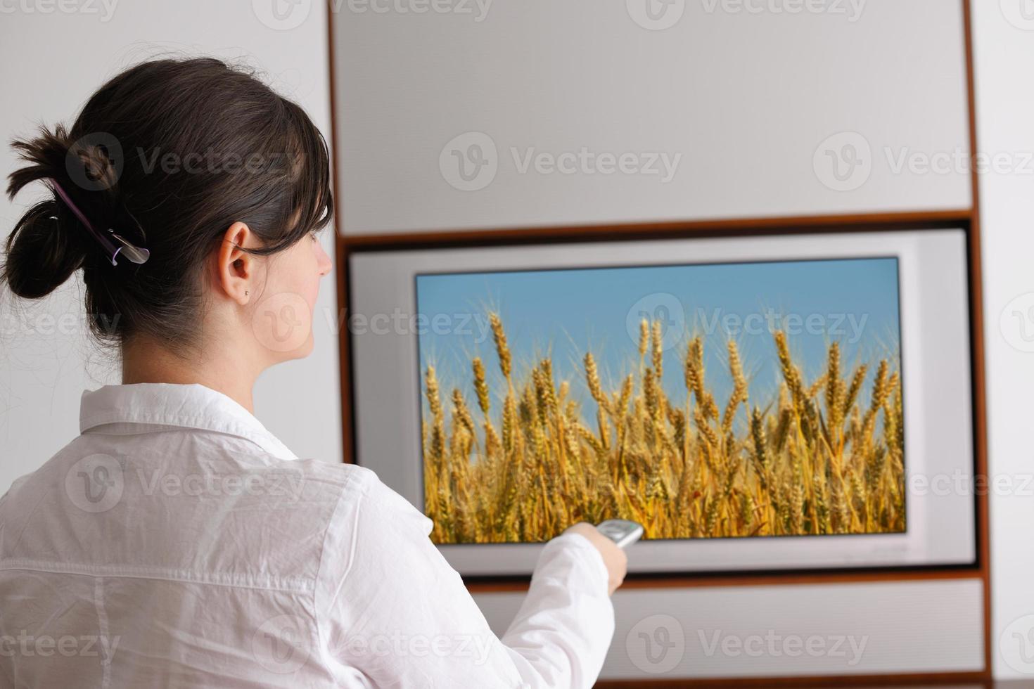 young woman watching tv at home photo