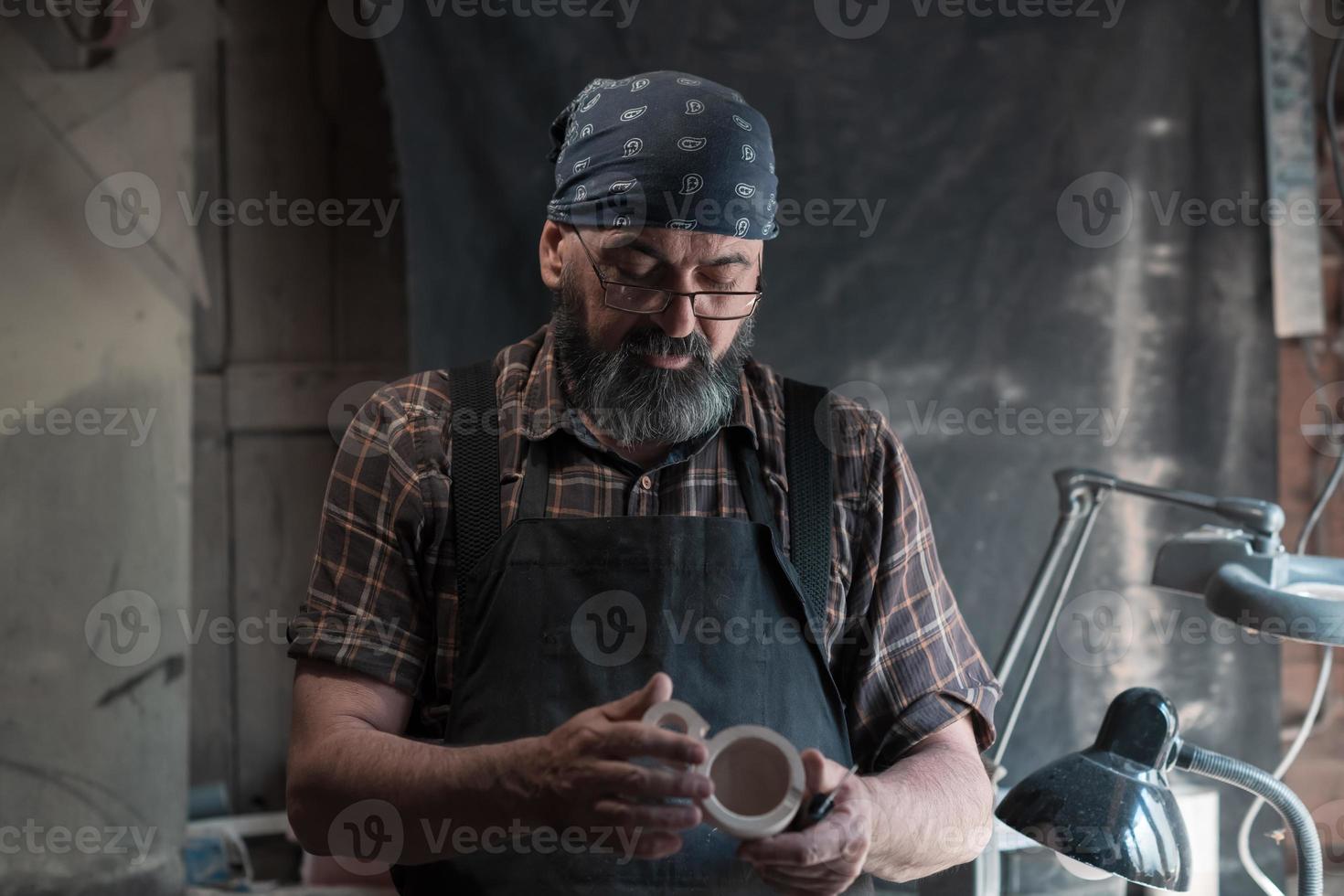 maestro de cucharas en su taller con productos y herramientas de madera foto