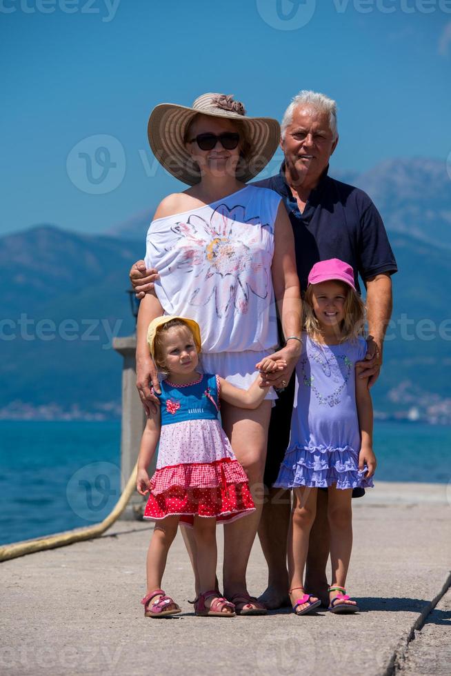 portrait of grandparents and granddaughters standing by the sea photo
