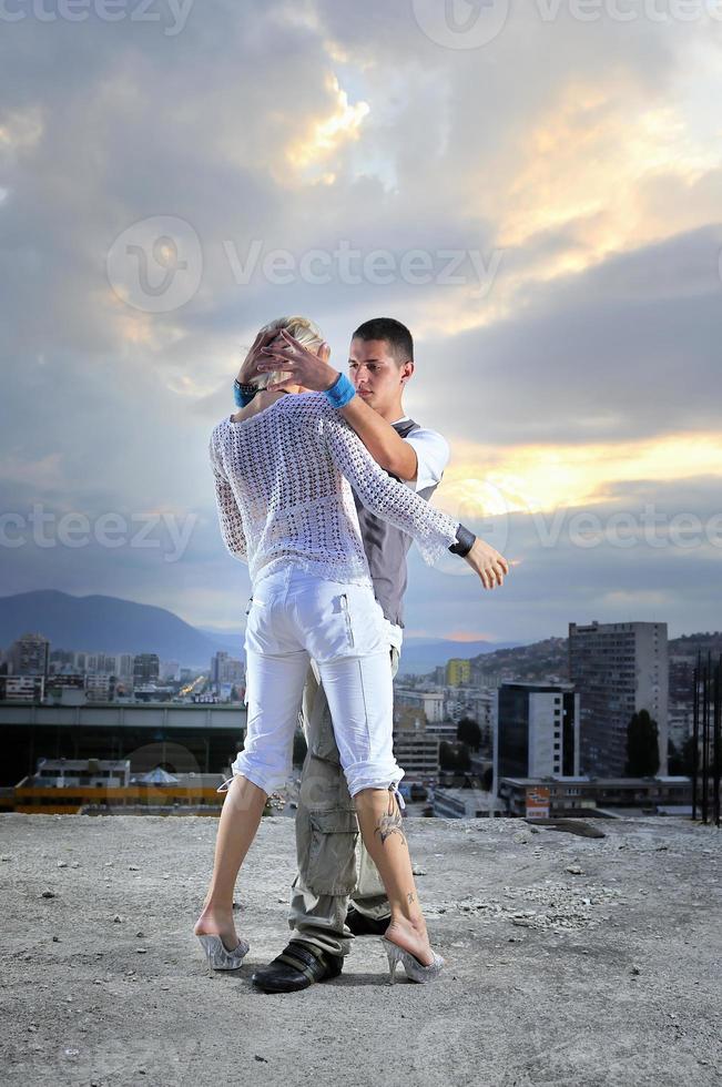 romantic urban couple dancing on top of  bulding photo