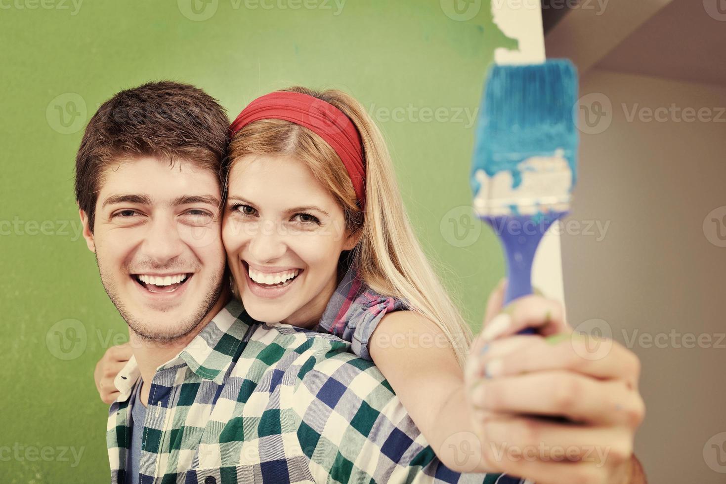 happy couple paint wall at new home photo