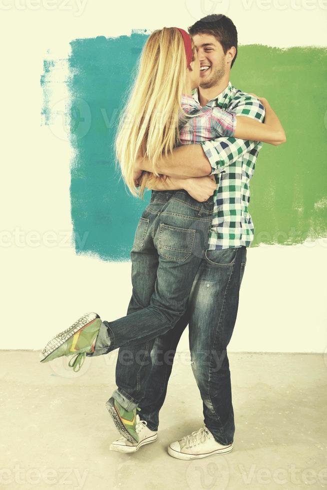 happy couple paint wall at new home photo