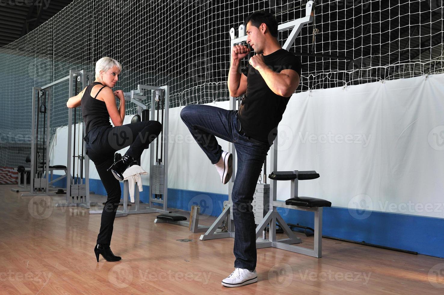 woman in the fitness gim working out with personal trainer photo