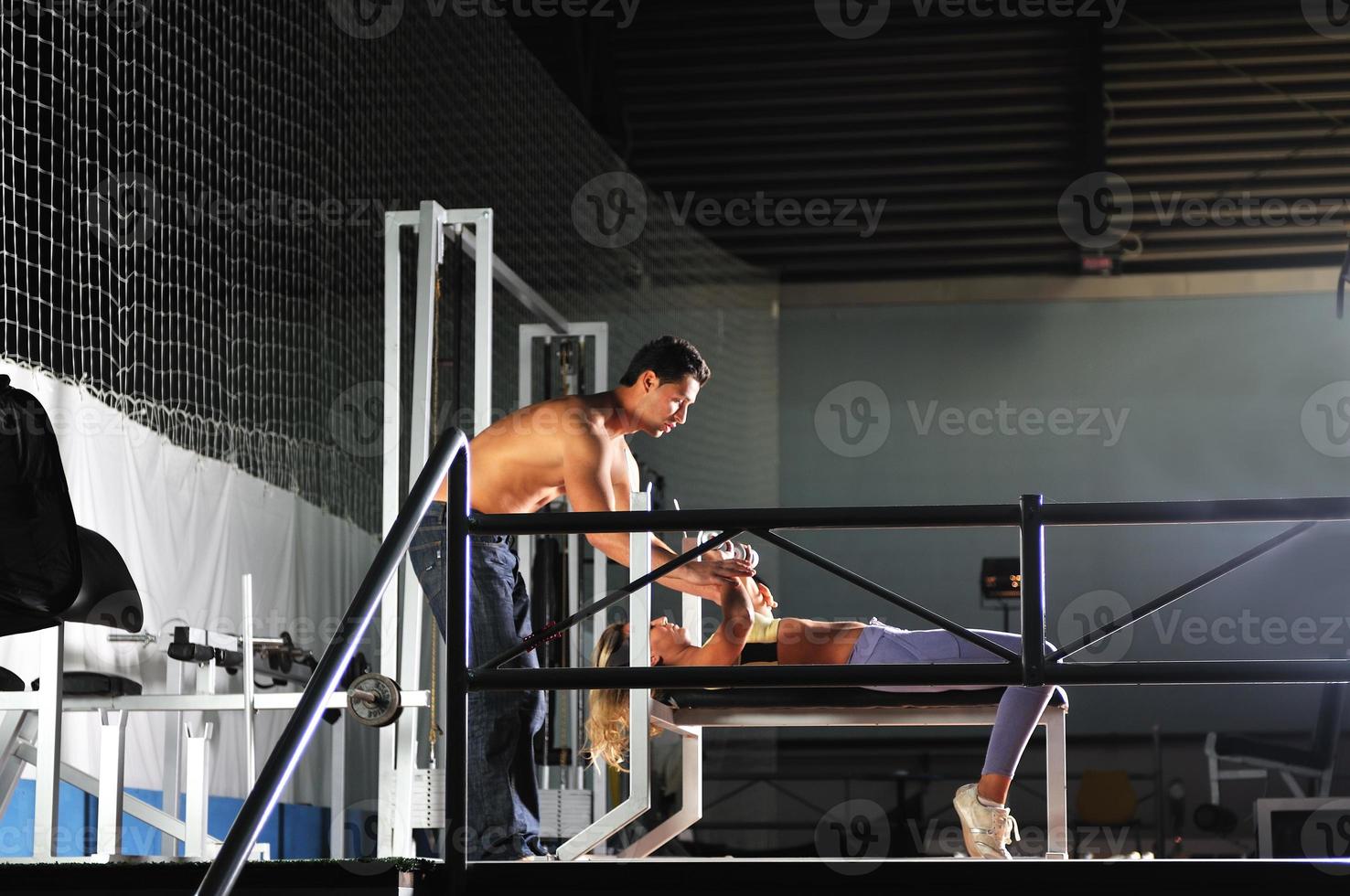 woman in the fitness gim working out with personal trainer photo