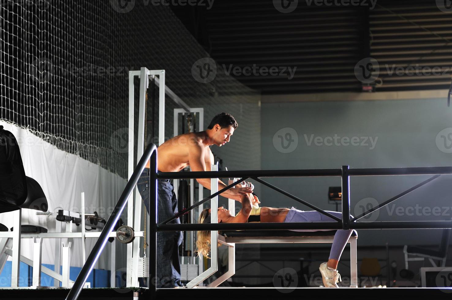 mujer en el gim de fitness trabajando con entrenador personal foto