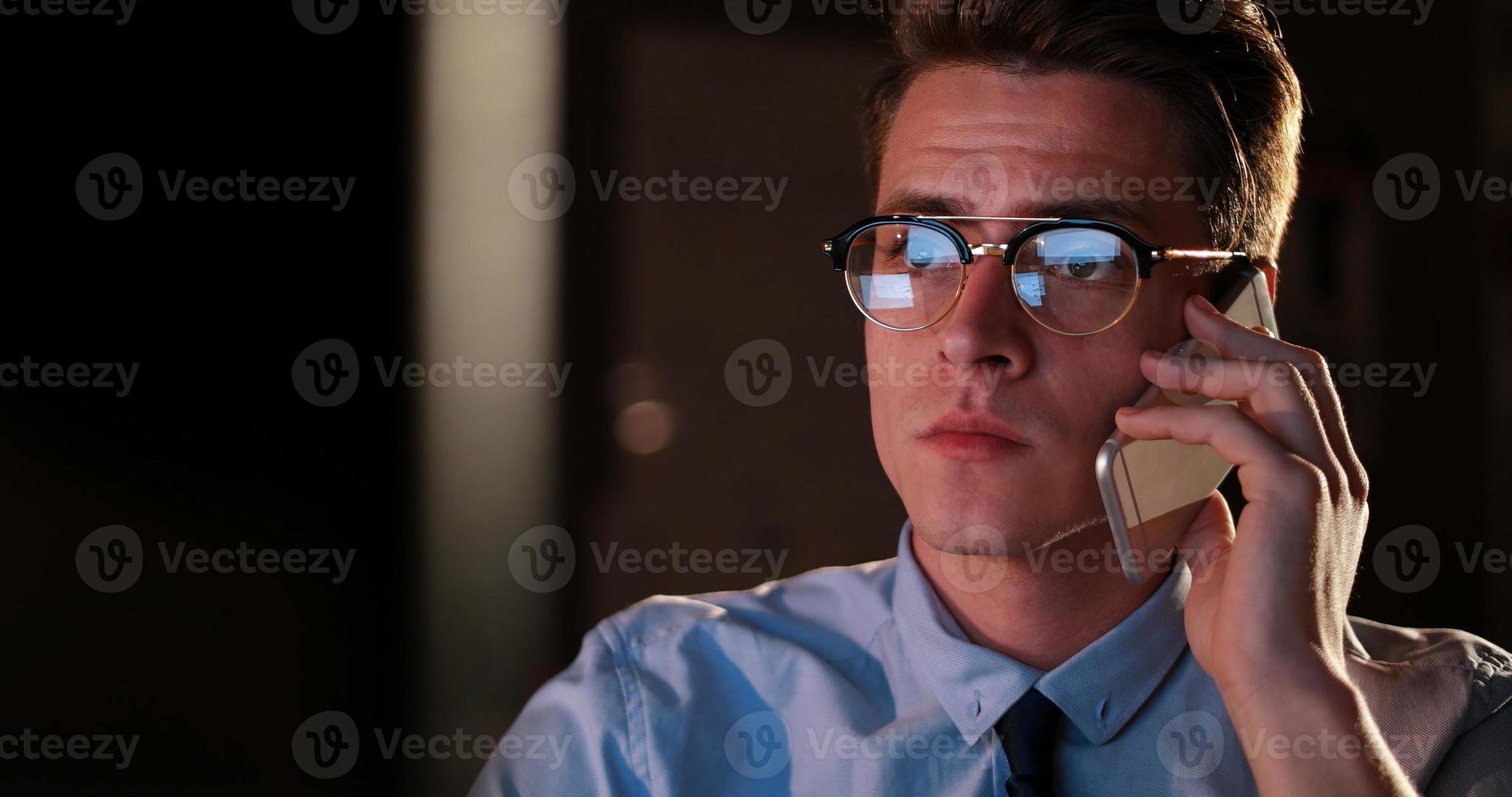 man using mobile phone in dark office photo