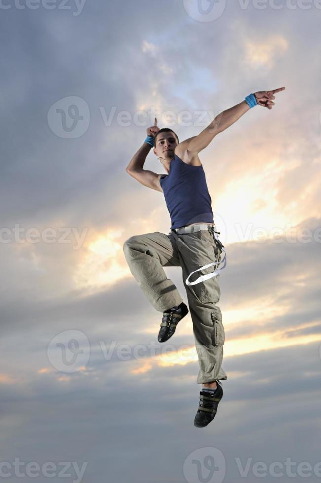 young man dancing and jumping  on top of the building photo