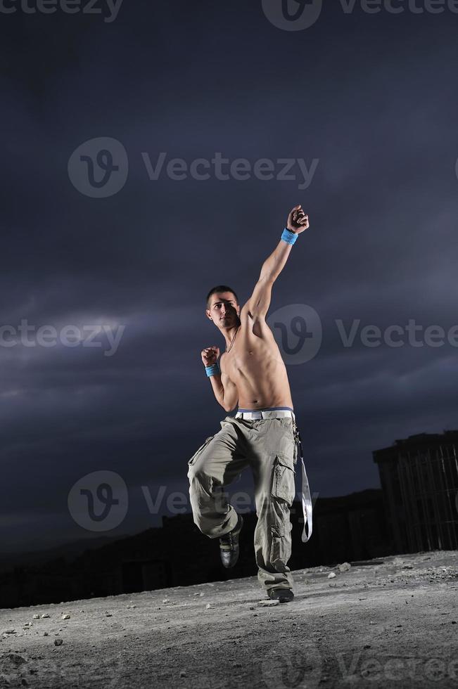 young man dancing and jumping  on top of the building photo