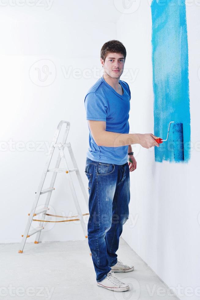 handsome young man paint white wall in color photo