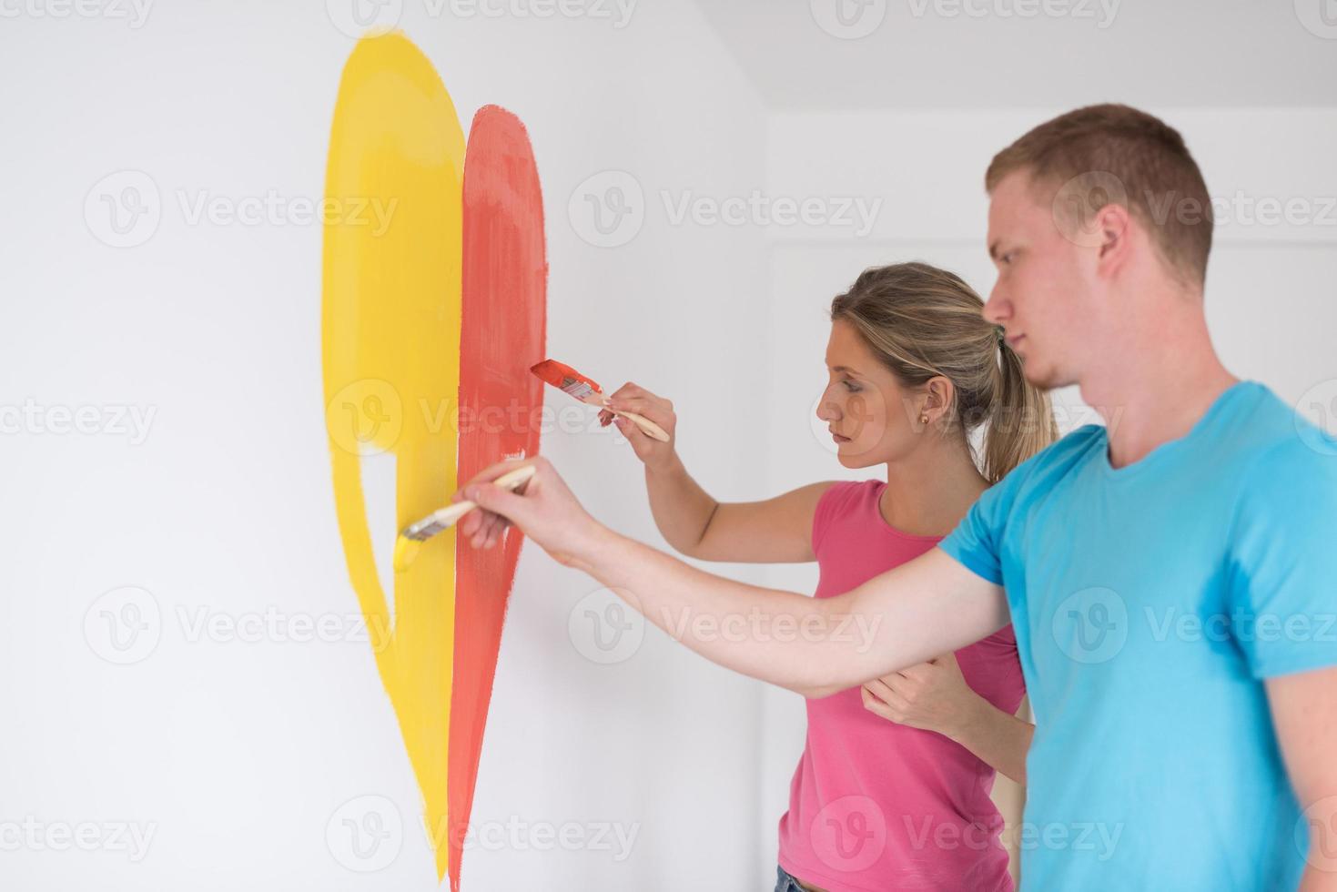 couple are painting a heart on the wall photo