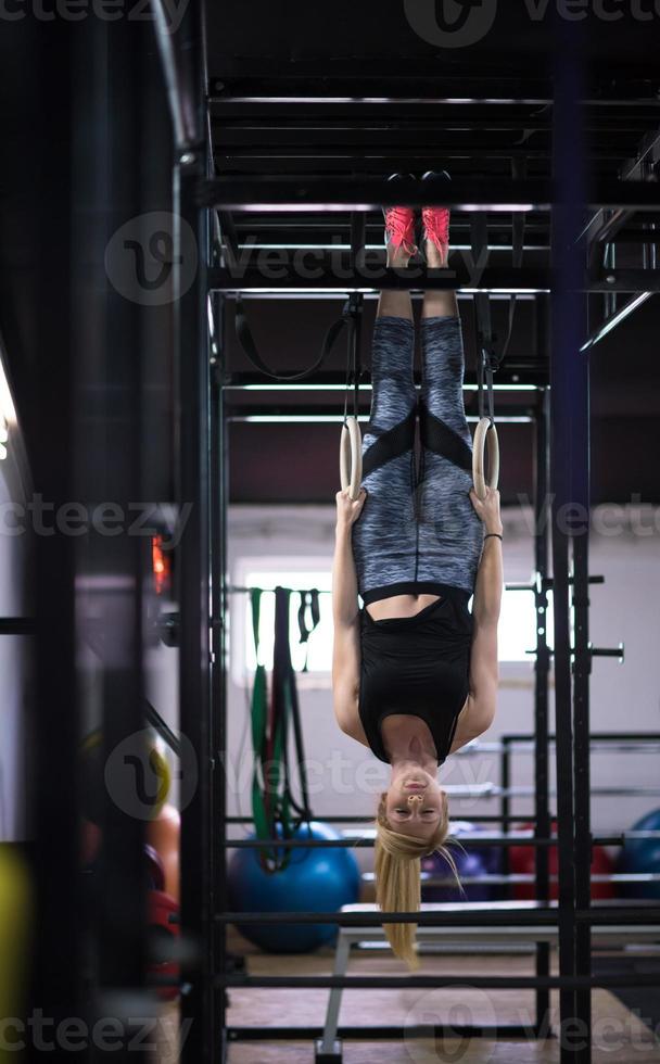 mujer trabajando en anillos de gimnasia foto