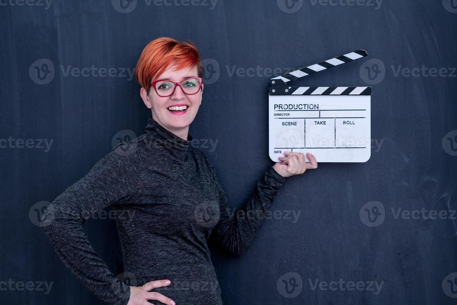 redhead woman holding movie clapper photo