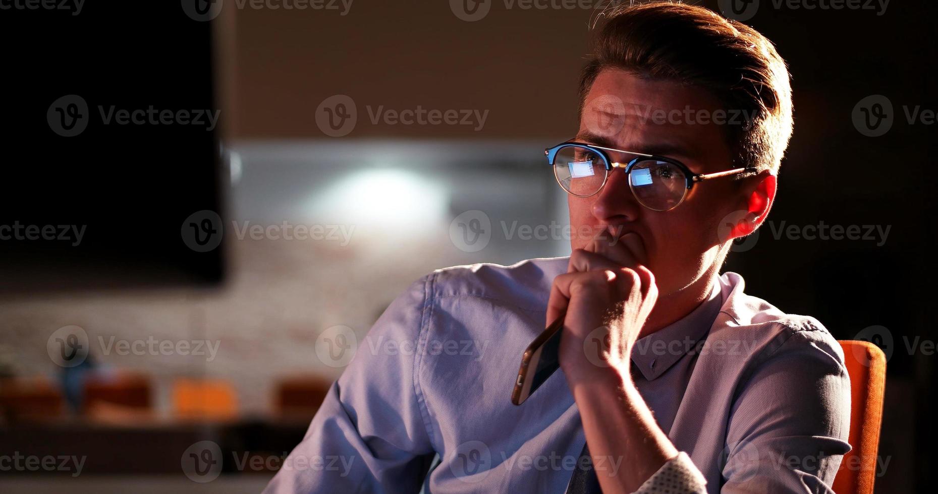 hombre trabajando en una computadora en una oficina oscura foto