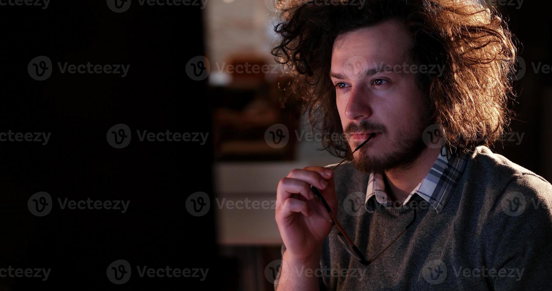 man working on computer in dark office photo