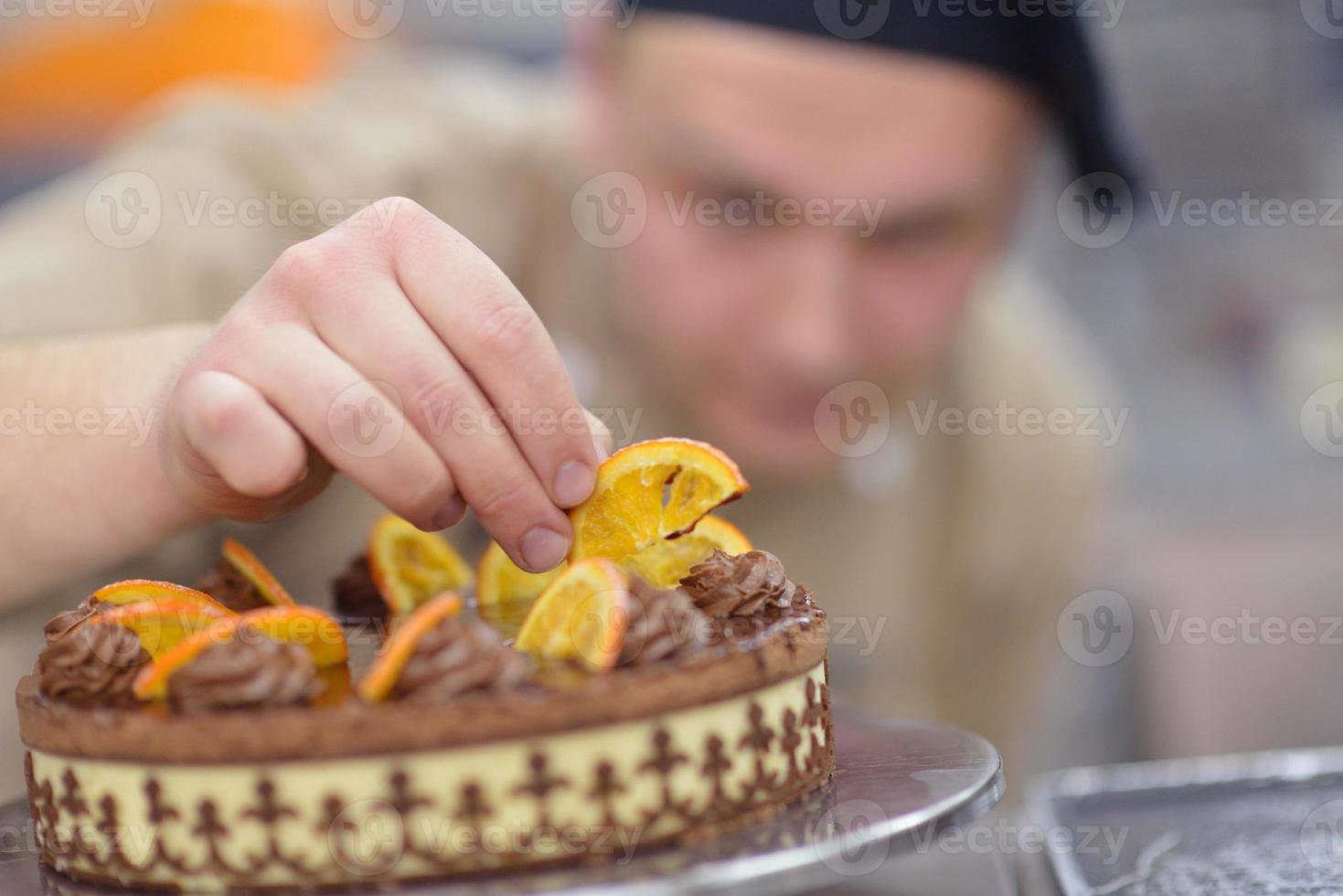 chef preparando pastel de desierto en la cocina foto