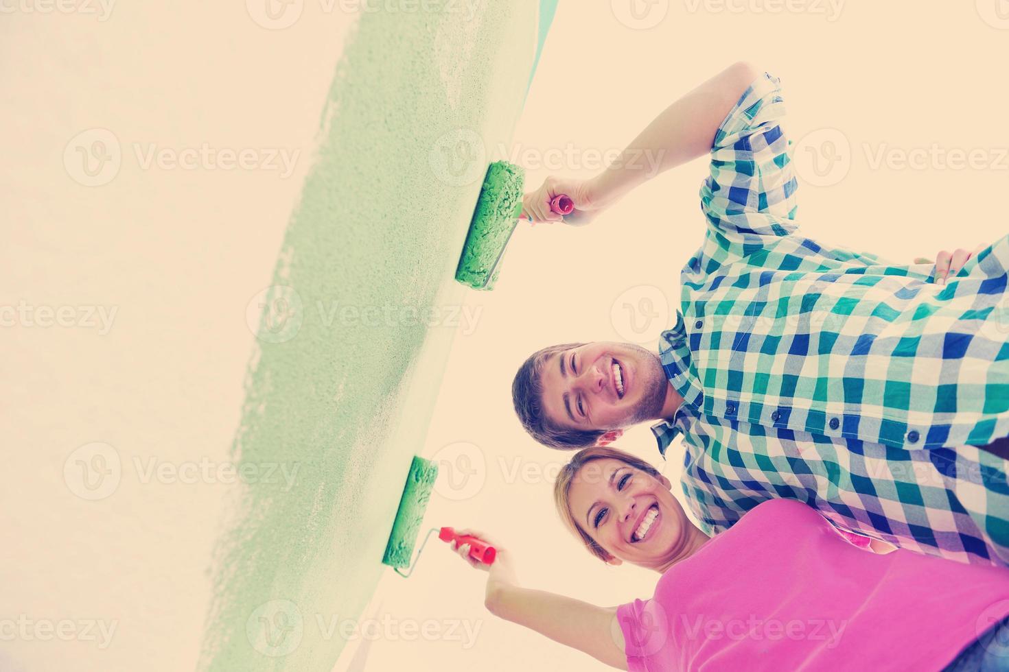 happy couple paint wall at new home photo
