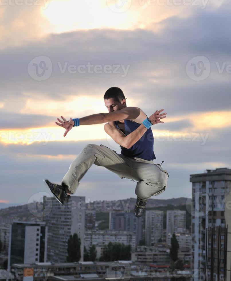 young man jumping in air outdoor at night ready for party photo