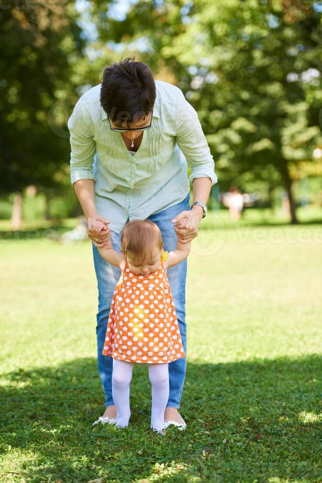 mother and baby in park making first steps photo