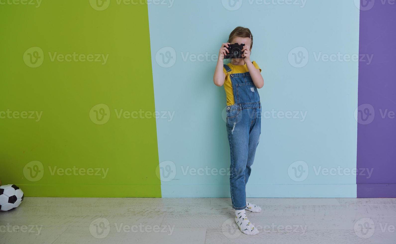 Cute little girl taking picture using  film photo camera