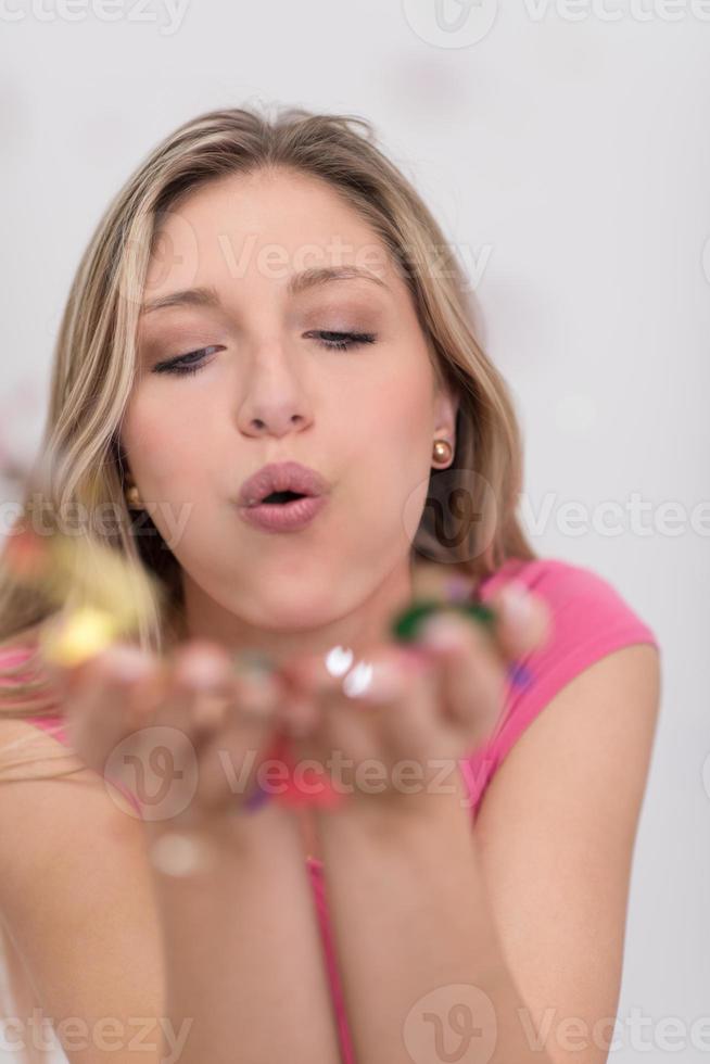 mujer soplando confeti en el aire foto