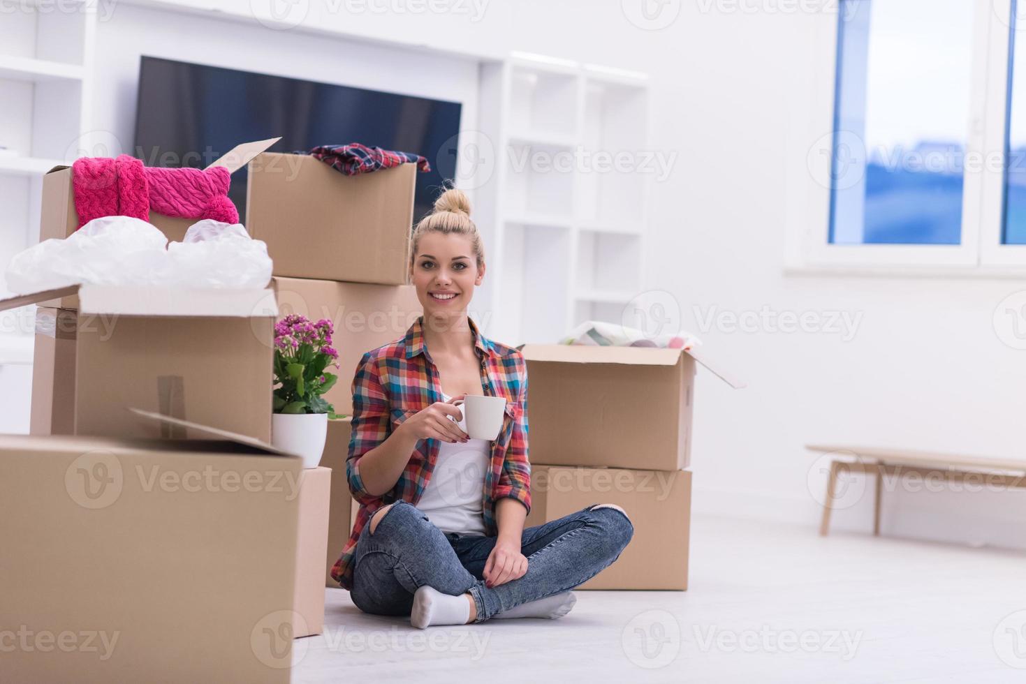 woman with many cardboard boxes sitting on floor photo