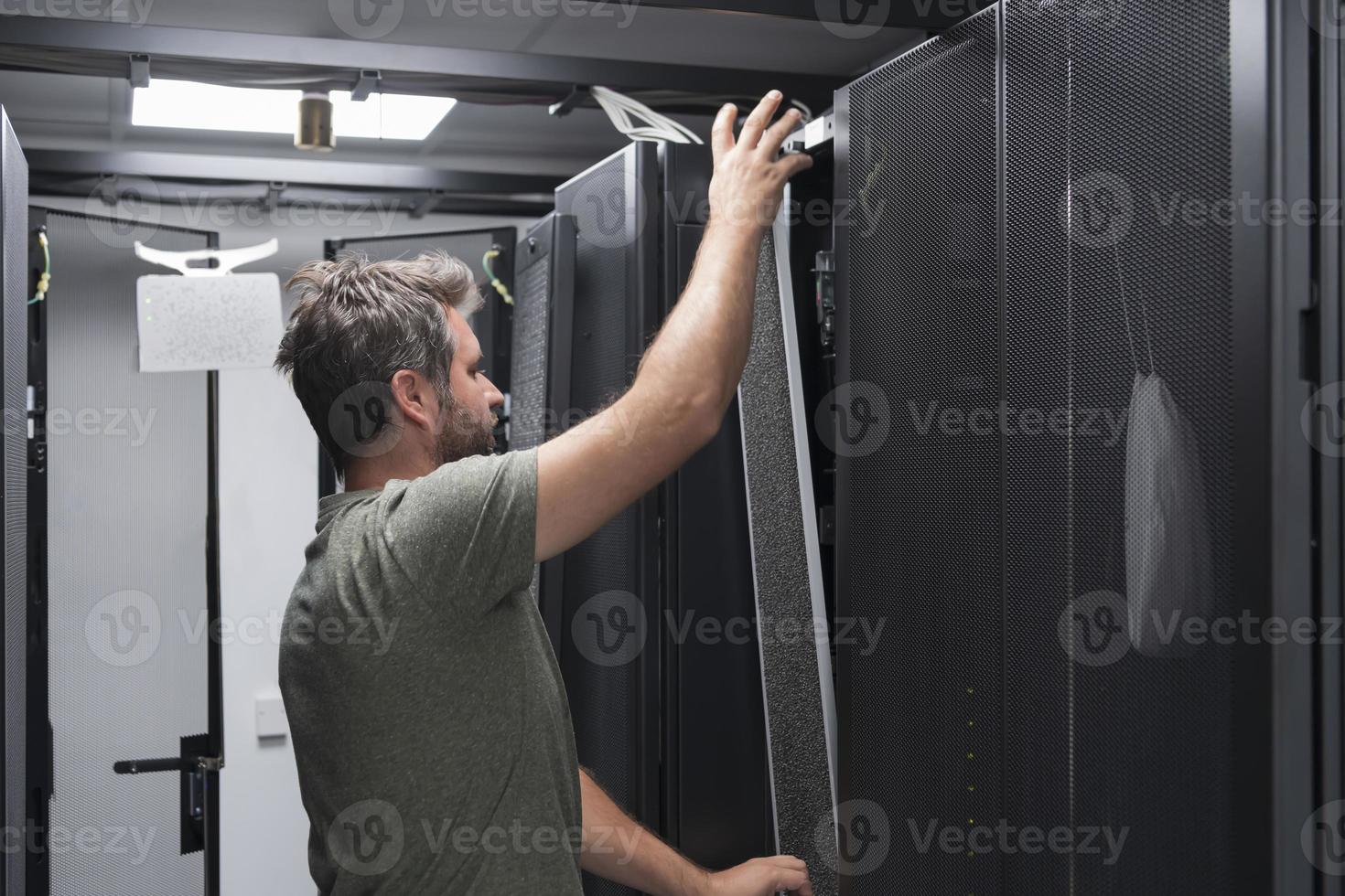 IT engineer working In the server room or data center The technician puts in a rack a new server of corporate business mainframe supercomputer or cryptocurrency mining farm. photo