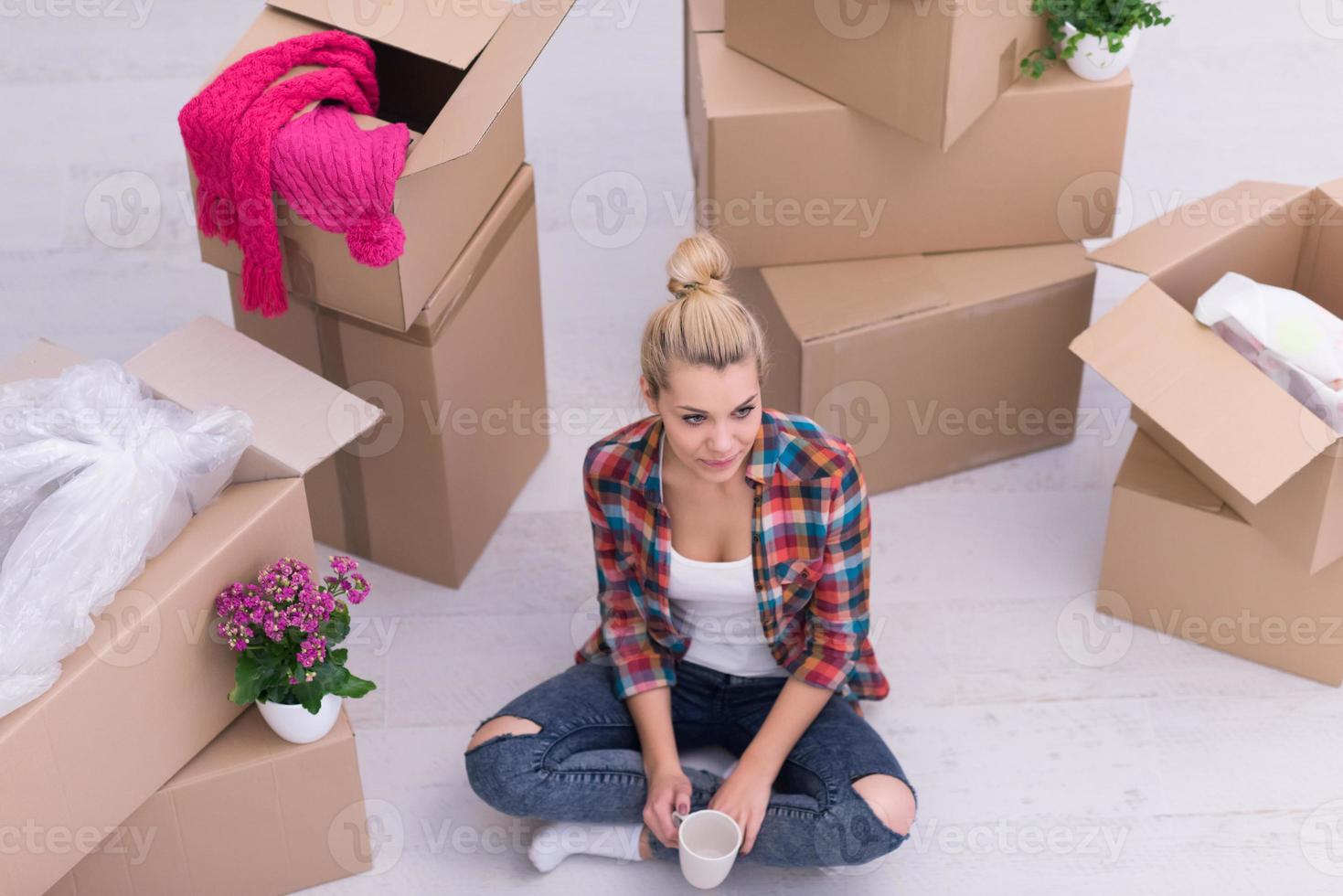 woman with many cardboard boxes sitting on floor photo