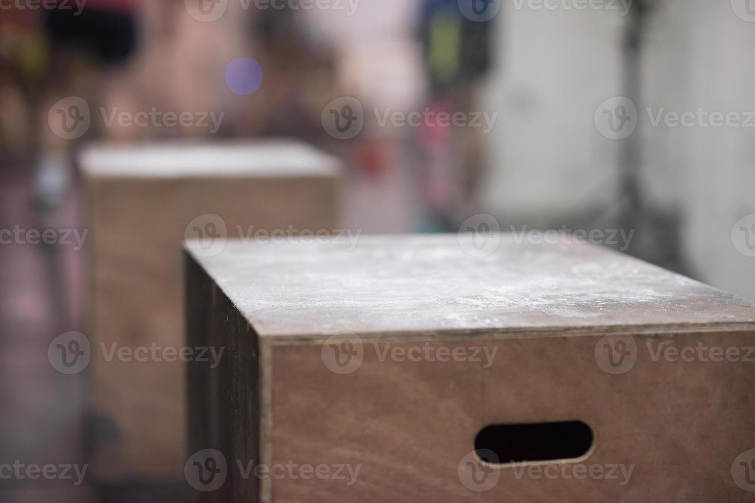 black woman is performing box jumps at gym photo