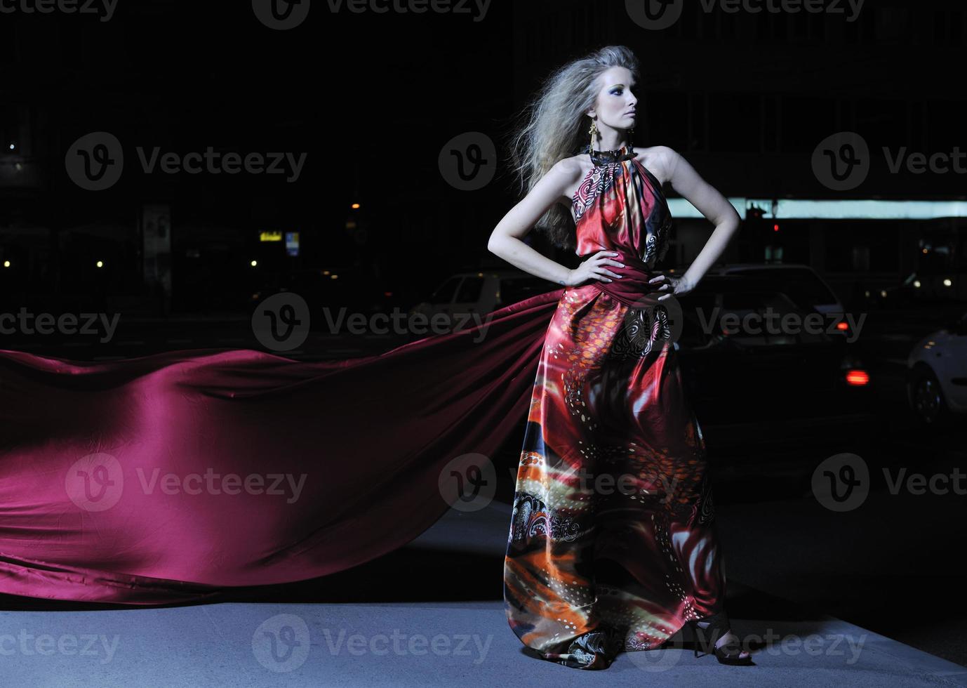 elegant woman on city street at night photo