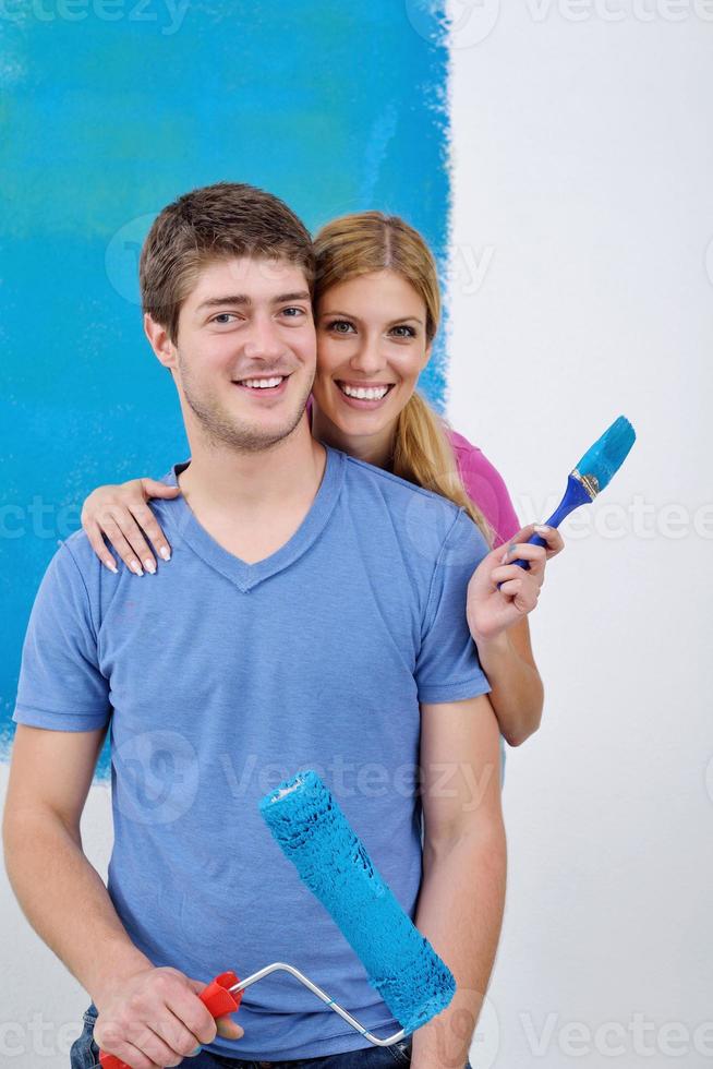 happy couple paint wall at new home photo