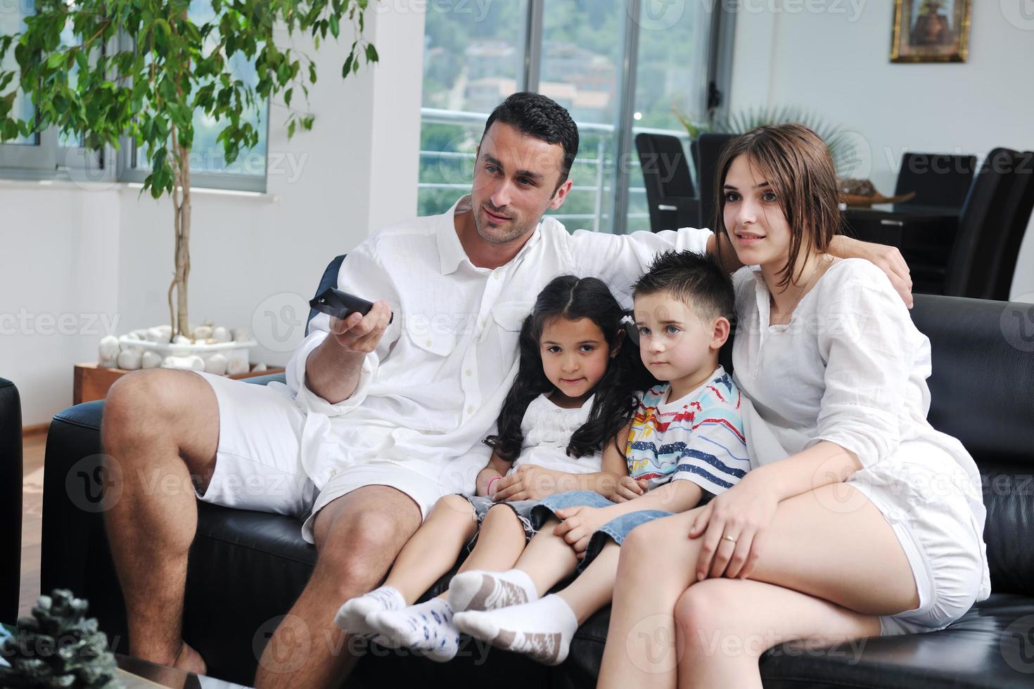 familia viendo televisión plana en casa moderna interior foto