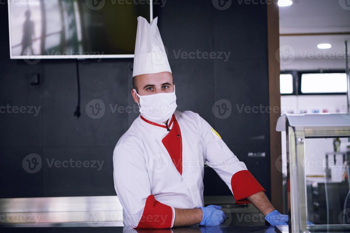 chef cook wearing face protective medical mask for protection from coronavirus photo