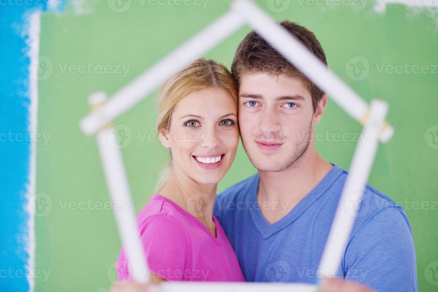 happy couple paint wall at new home photo